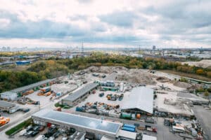 Luftaufnahme der Recyclinganlage der Cemex Heim RC-Baustoffe mit Hallen, Materiallagern und großen Schüttgut Halden am Stadtrand von Berlin